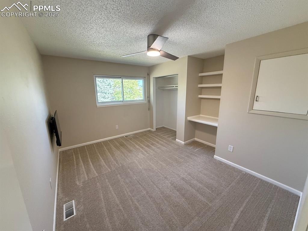 Image 13 of 32: Bedroom 2 with built in desk/shelves