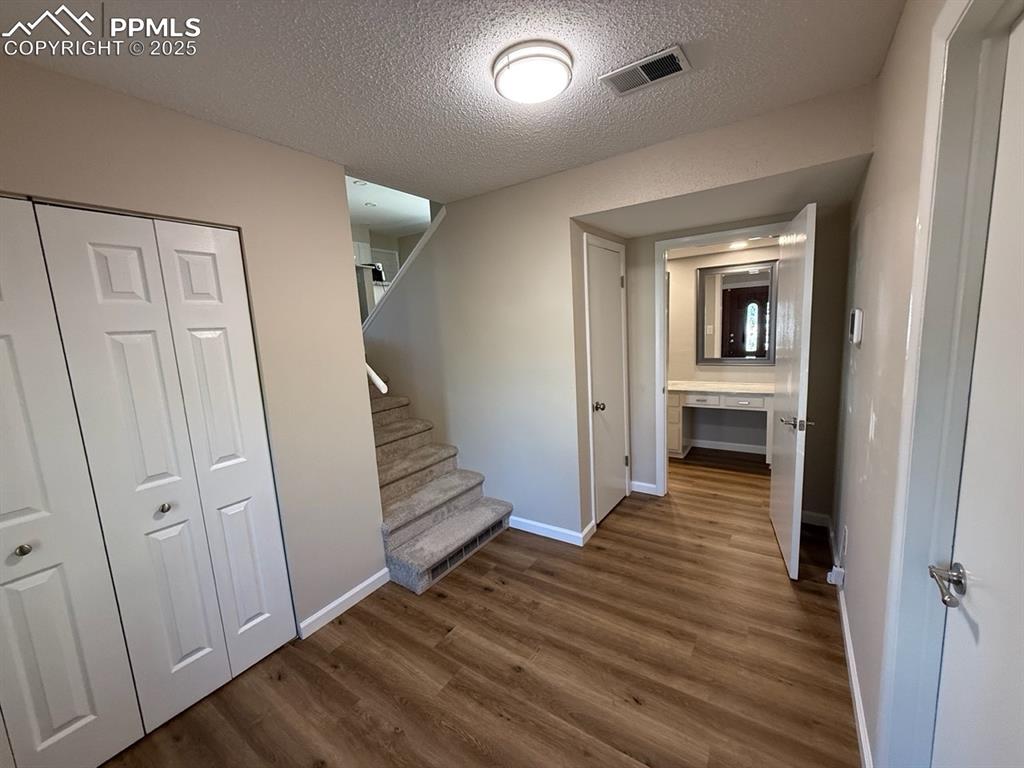 Image 4 of 32: Corridor featuring stairs, Vinyl wood-style floors
