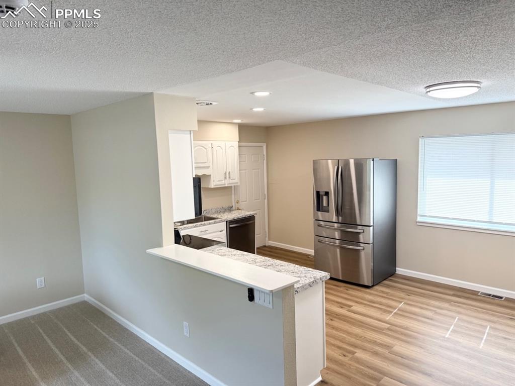 Image 5 of 32: Kitchen with stainless steel fridge with ice dispenser, a peninsula, dishwa