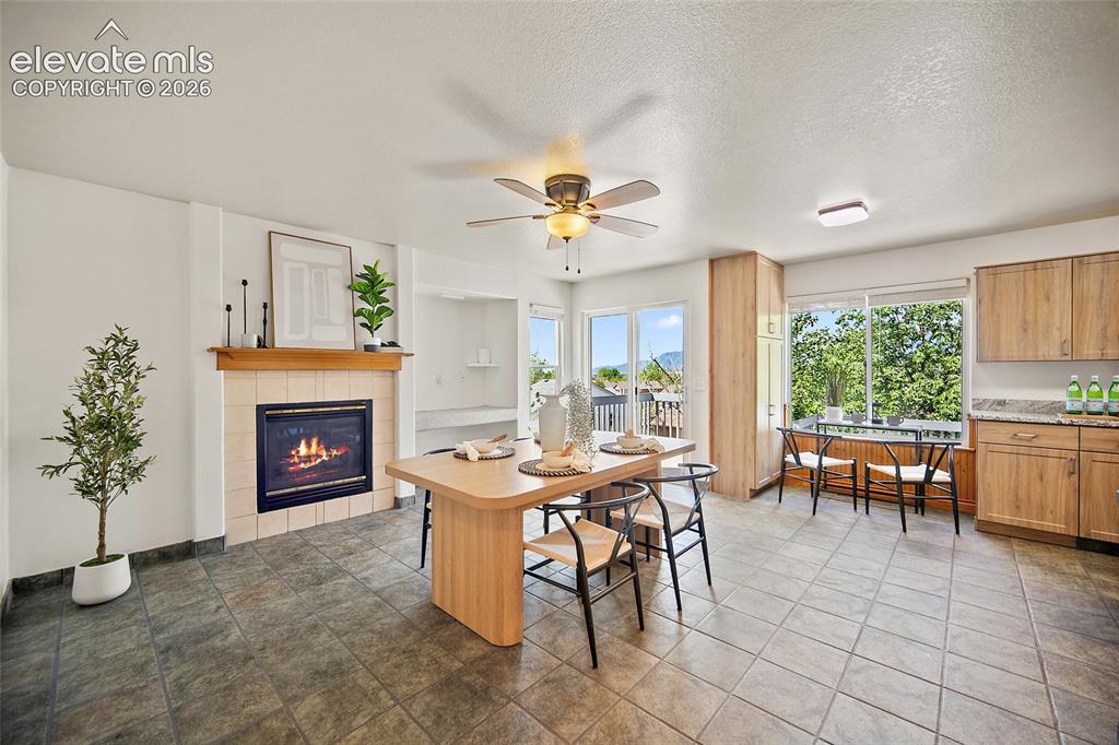 Image 10 of 45: Spacious open-concept room featuring a tiled fireplace with a wood mantel, 