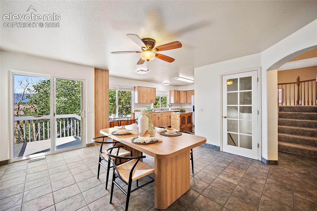 Image 12 of 45: Tile flooring extending from the dining area into the kitchen, featuring sl
