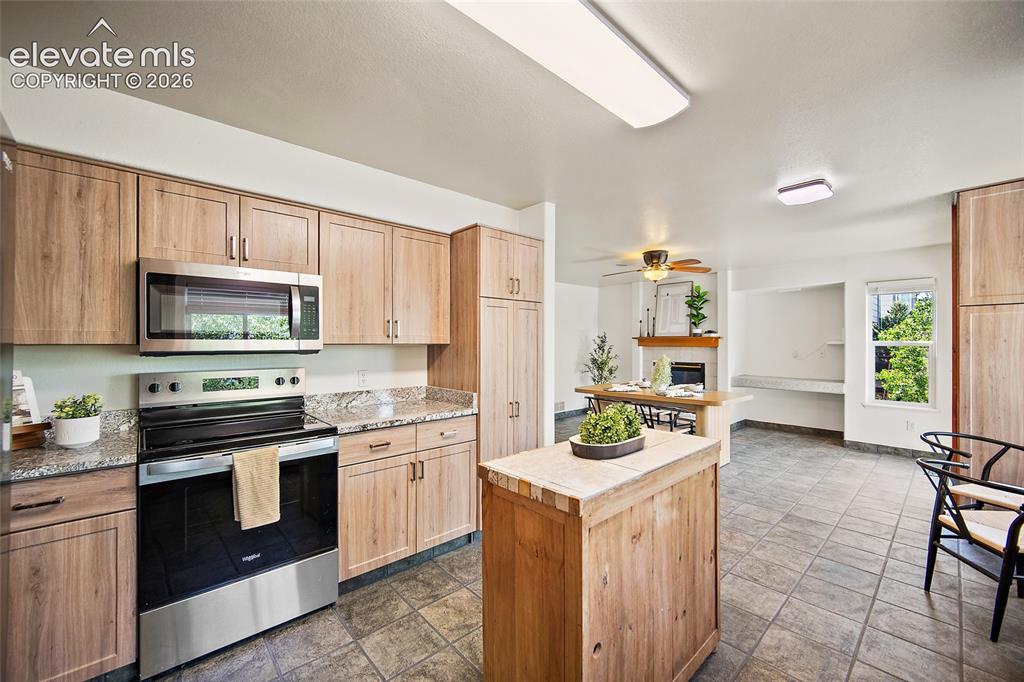 Image 13 of 45: Kitchen featuring wood-finish cabinetry, stainless steel appliances, granit