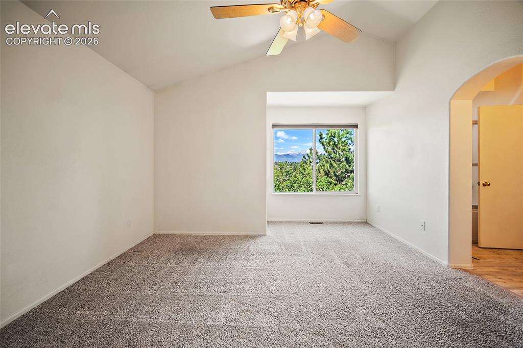 Image 22 of 45: Carpeted room featuring a window with expansive outdoor scenery, a vaulted 