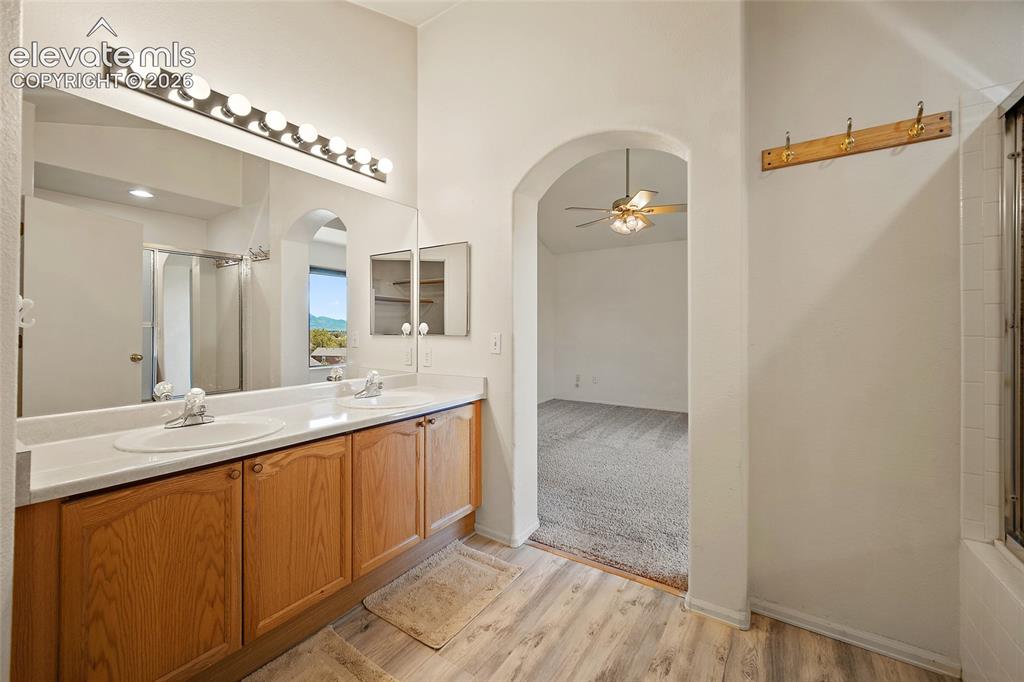 Image 27 of 45: Dual vanity with light wood-finish cabinetry, white countertops, and integr