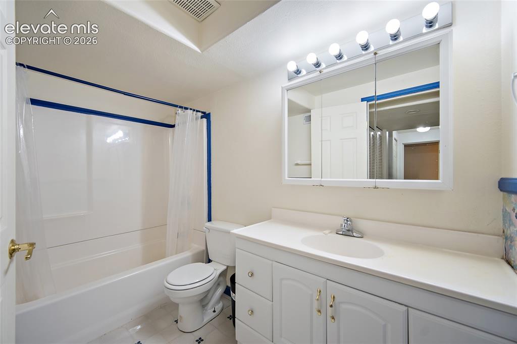 Image 37 of 45: Bathroom featuring a white vanity with integrated sink, white cabinetry wit
