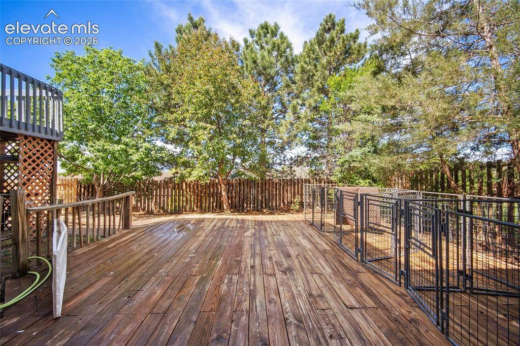 Image 39 of 45: Spacious wood deck featuring a protective railing and integrated metal encl