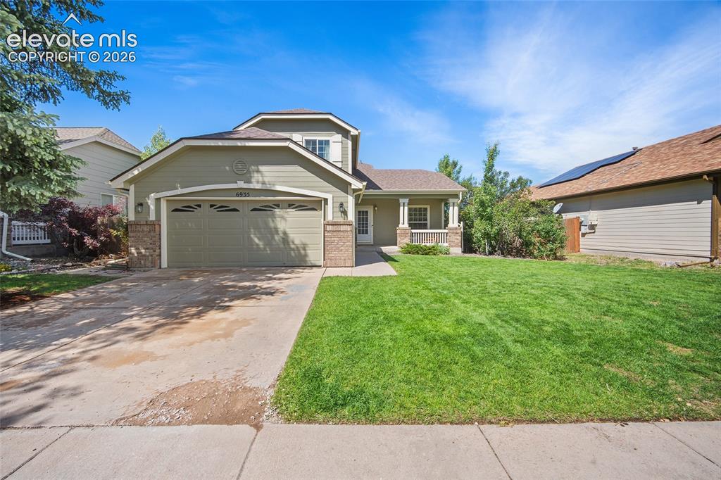 Image 44 of 45: Two-story residence featuring a covered front porch, an attached two-car ga