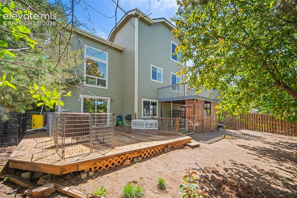 Image 5 of 45: Rear exterior featuring a multi-level wood deck, an upper-level balcony, an
