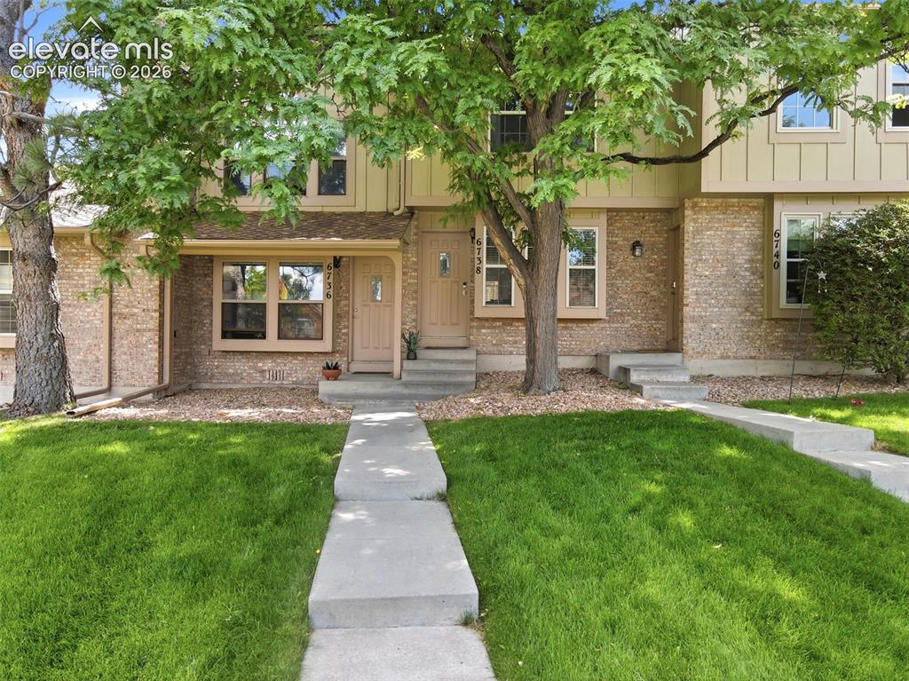 Image 1 of 49: Welcoming front walkway with large shade trees.