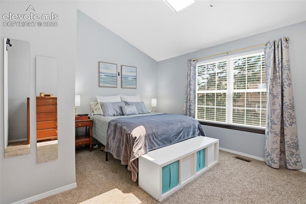 Image 18 of 49: The primary bedroom is full of natural light from the large windows and sky