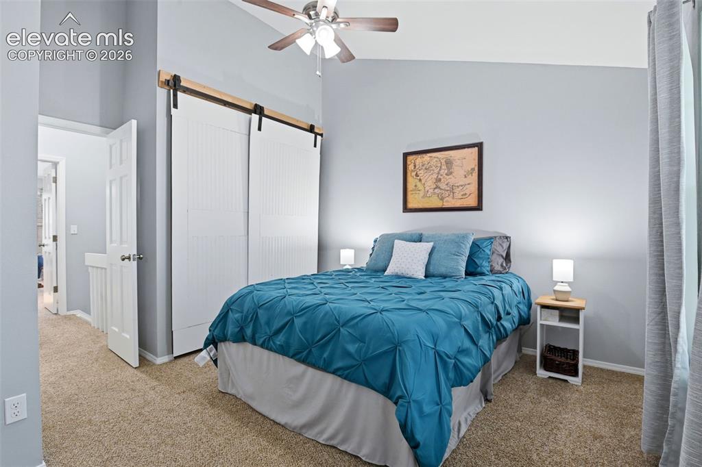 Image 26 of 49: The barn door accents the closet of the second bedroom.