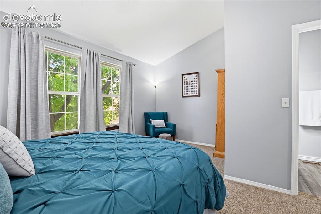 Image 28 of 49: Second bedroom with views of shade trees.
