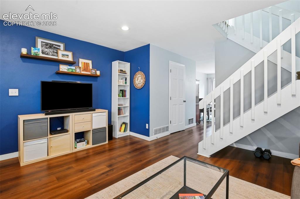 Image 6 of 49: Beautiful floors and a contemporary accent wall in living room.