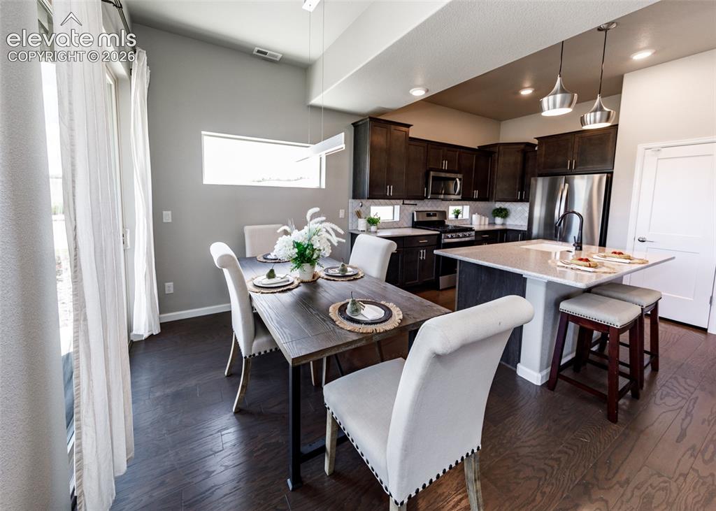 Image 14 of 50: Open-concept living space featuring wood-finish flooring, a kitchen with da
