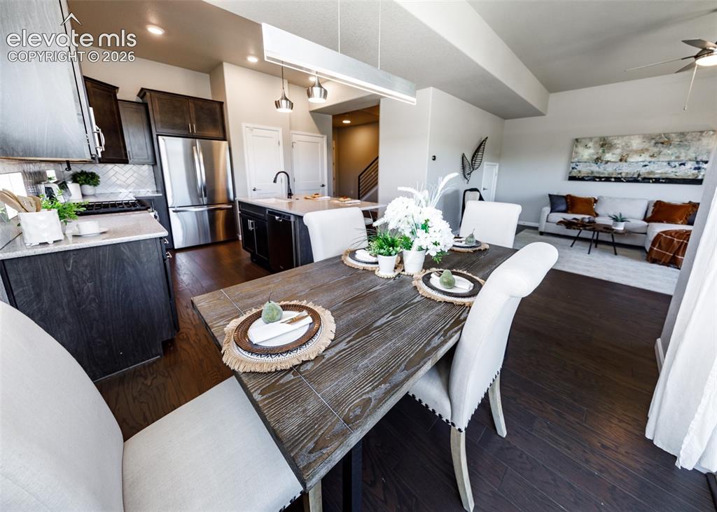 Image 16 of 50: Open-concept living space with dark wood-finish flooring