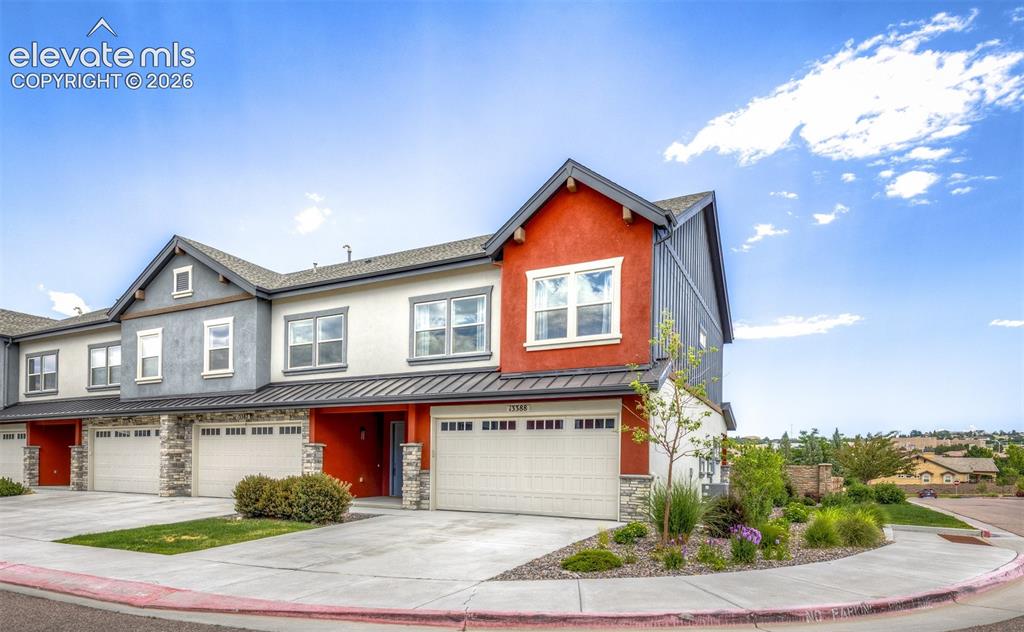 Image 2 of 50: Modern townhome with multi-tone siding, decorative stone accents, and a two