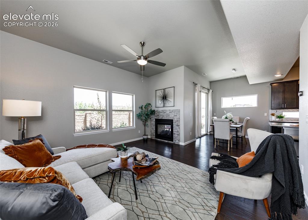 Image 21 of 50: Spacious living area featuring dark wood-finish flooring, a contemporary ce