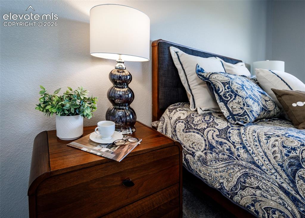 Image 30 of 50: Wood-finish bedside table with a curved profile and single drawer