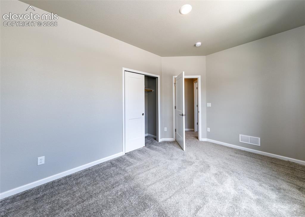 Image 39 of 50: Neutral-toned room featuring a soft gray carpet, light gray wall paint, and