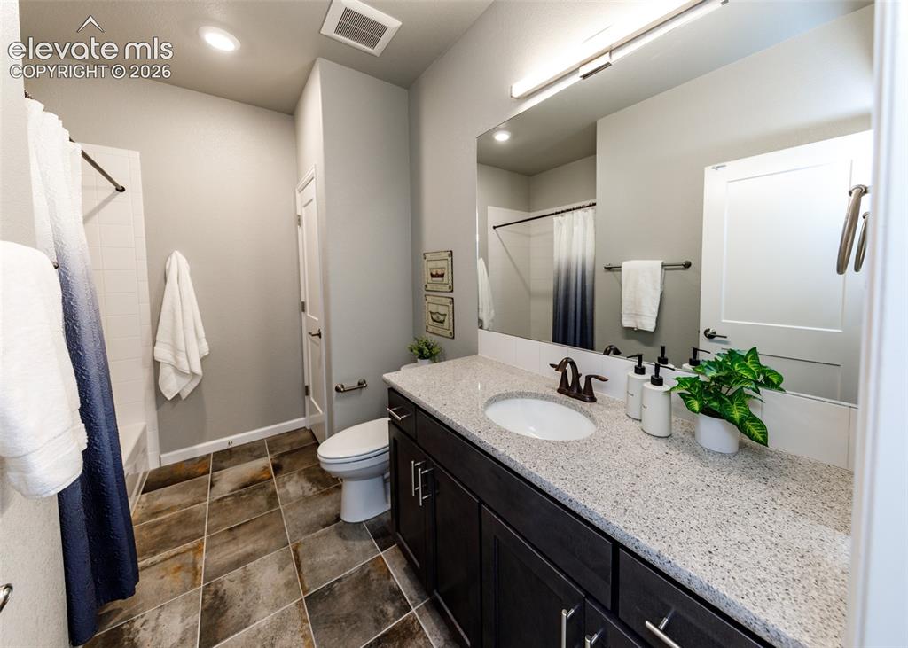Image 40 of 50: Bathroom featuring a dark wood-finish vanity with a light speckled countert