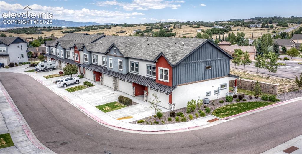 Image 49 of 50: Townhome row featuring individual garages, multi-toned siding, and gabled r