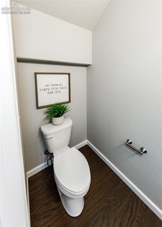 Image 5 of 50: Compact powder room featuring wood-finish flooring, a contemporary toilet, 