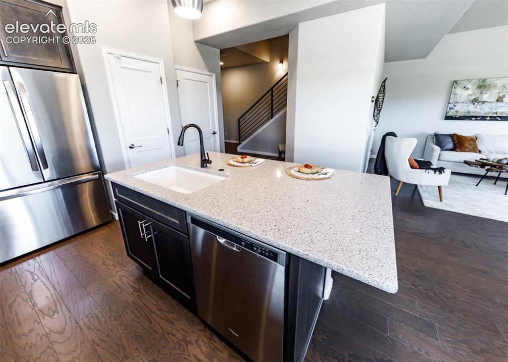 Image 7 of 50: Kitchen island featuring a white undermount sink, a matte black faucet, and