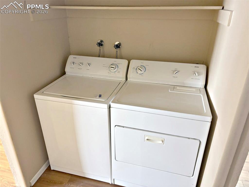 Image 12 of 17: Laundry area featuring independent washer and dryer and light wood-type flo
