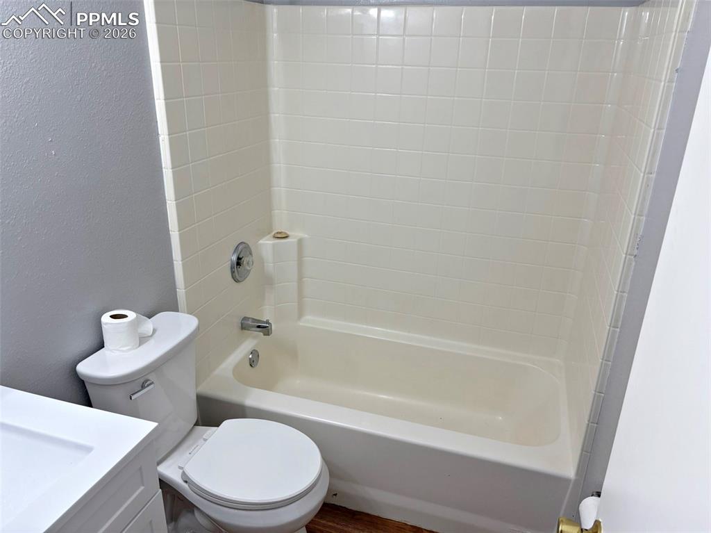 Image 16 of 17: Bathroom featuring vanity, a textured wall, bathtub / shower combination, a