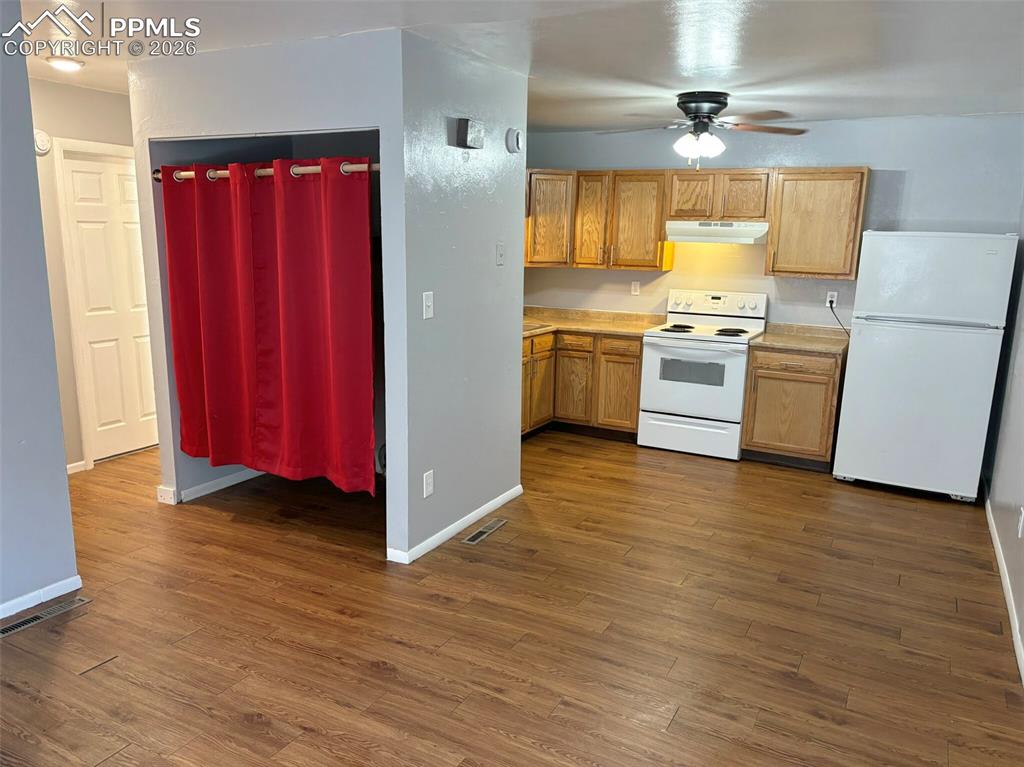 Image 7 of 17: Kitchen with light countertops, white appliances, dark wood-type flooring,