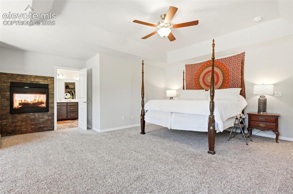 Image 17 of 44: Recessed fireplace with a stacked stone surround, light-colored carpeting, 