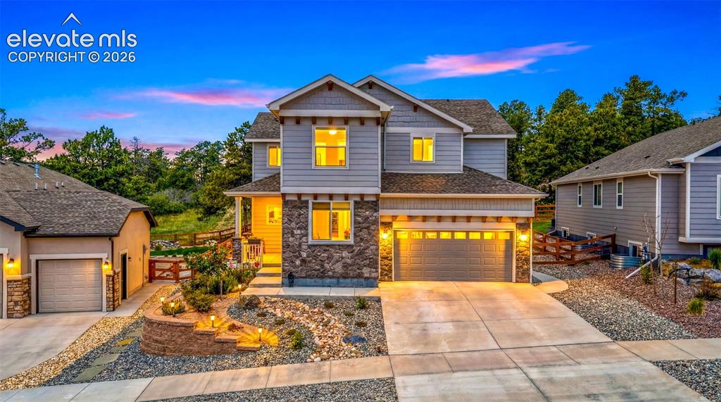 Image 2 of 44: Two-story residence featuring a stone and siding exterior with a prominent 
