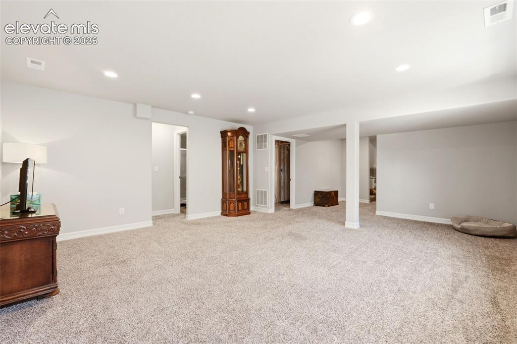 Image 28 of 44: Spacious room featuring light-colored carpeting, recessed lighting, white w