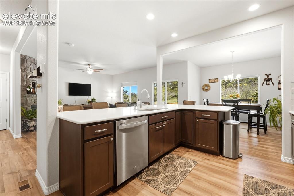 Image 4 of 44: Open-concept living area featuring wood-finish flooring, recessed lighting,