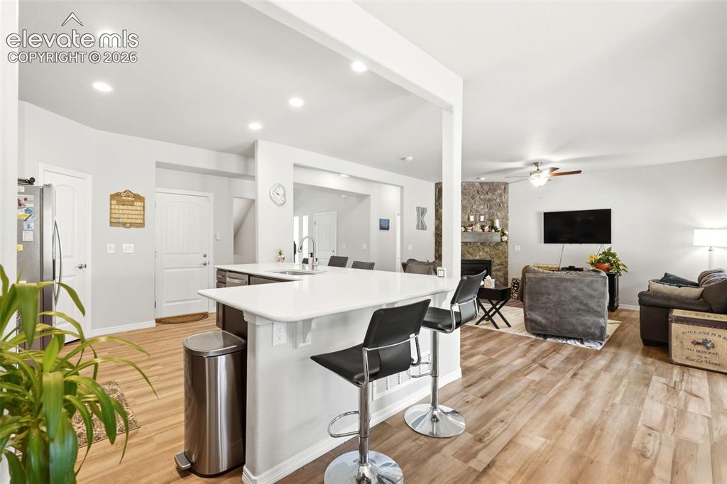 Image 5 of 44: Open-concept kitchen featuring wood-finish flooring, recessed lighting, whi