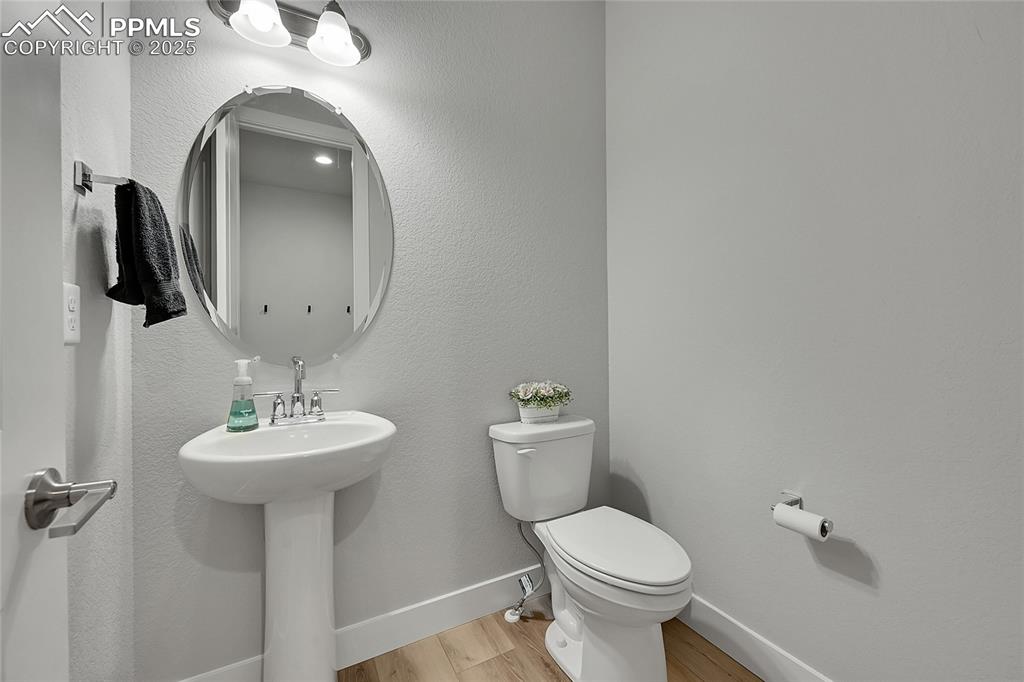 Image 15 of 44: Bathroom with wood finished floors and a textured wall