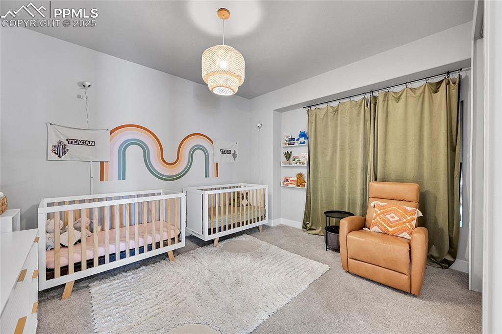 Image 23 of 44: Carpeted bedroom featuring baseboards and a nursery area