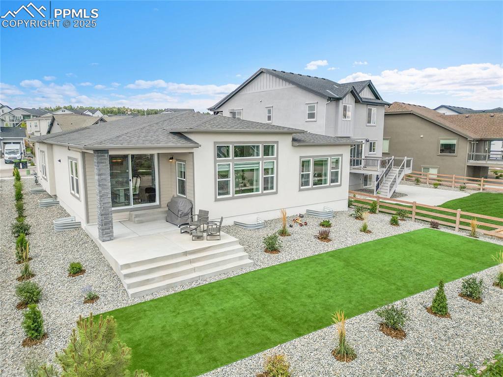 Image 37 of 44: Back of house with a shingled roof, stucco siding, a residential view, and