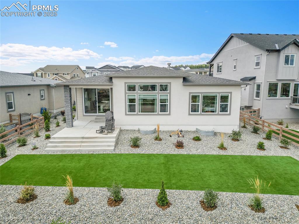 Image 38 of 44: Back of property featuring a shingled roof, a fenced backyard, a patio, and