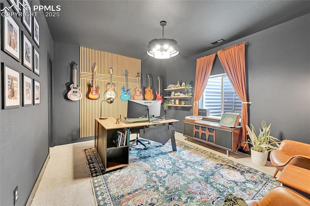 Image 4 of 44: Carpeted home office featuring a chandelier, a textured wall, and a texture