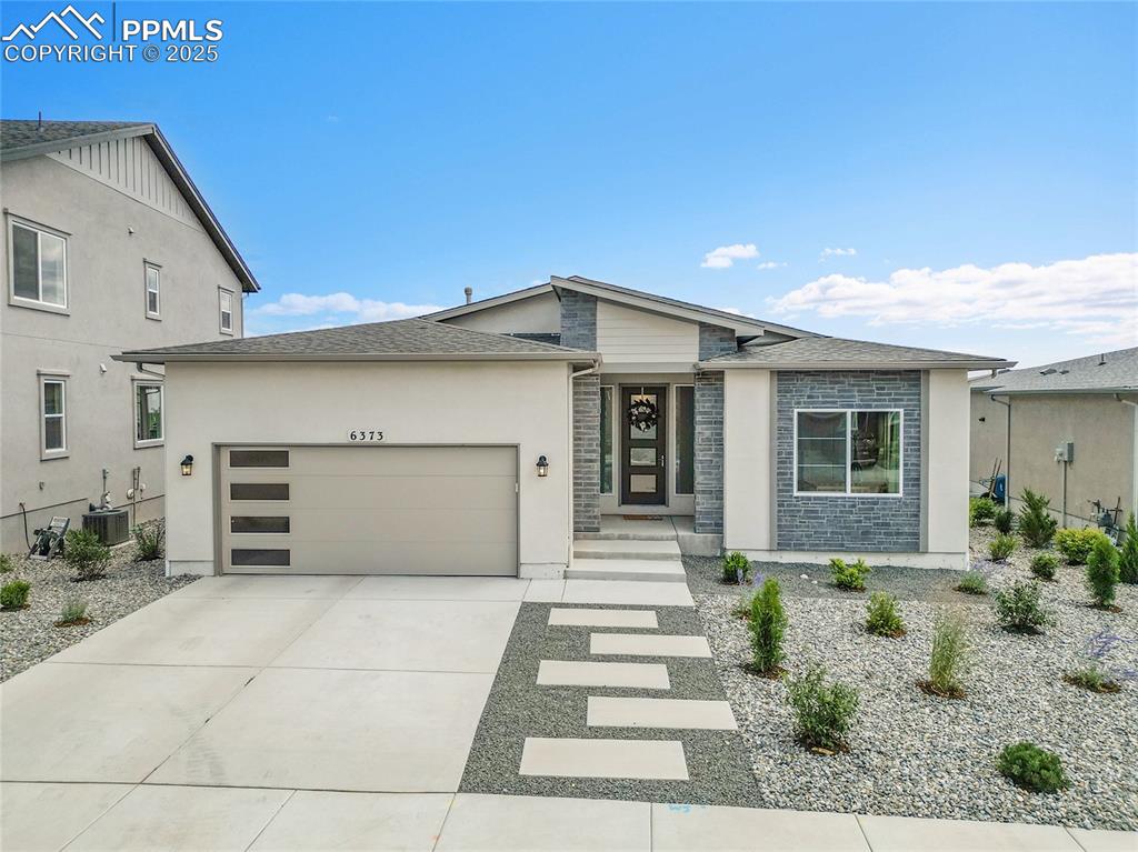 Image 41 of 44: View of front of property featuring an attached garage, roof with shingles,
