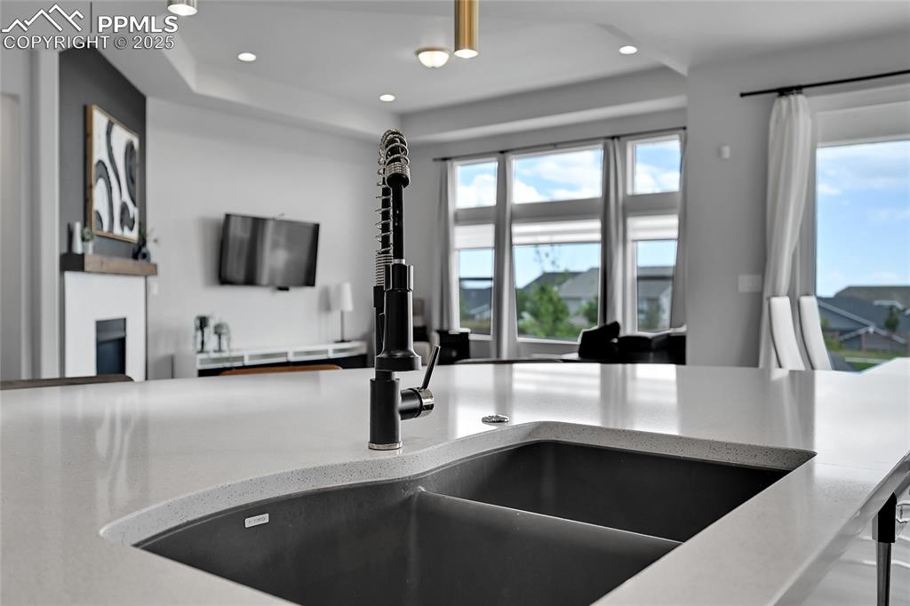 Image 9 of 44: Kitchen featuring healthy amount of natural light, light stone countertops,