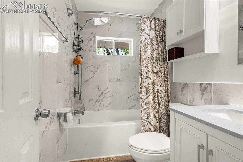 Image 13 of 30: Full bathroom with shower / tub combo, toilet, healthy amount of natural li