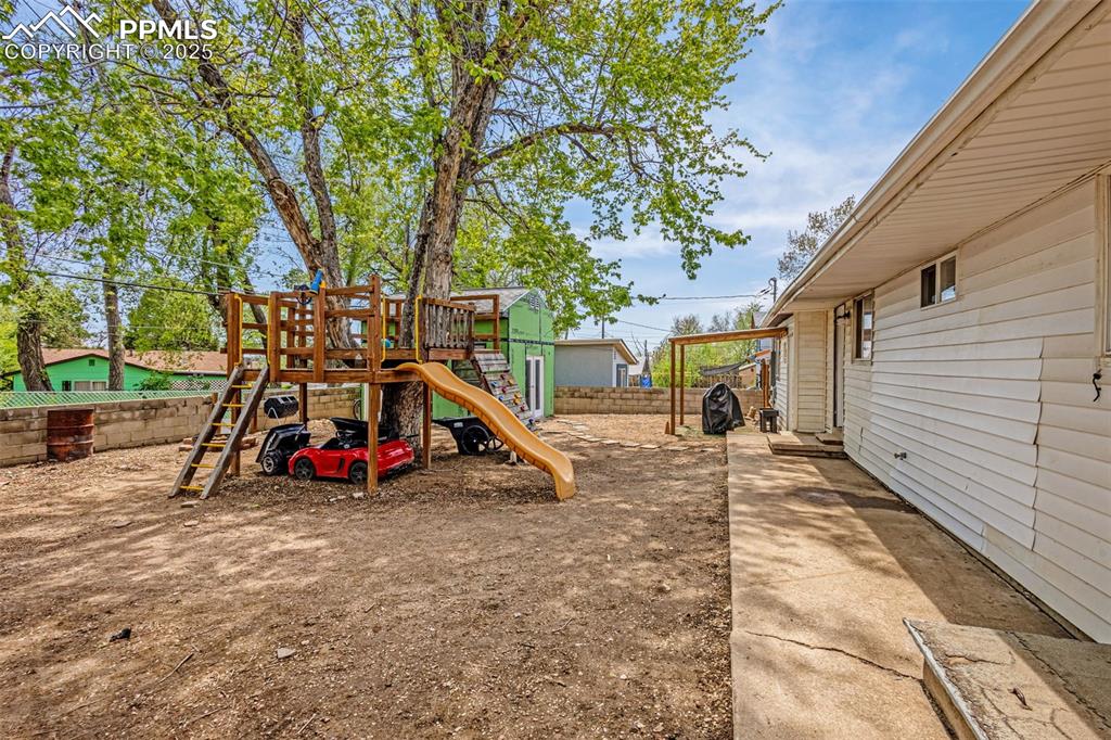 Image 20 of 30: View of jungle gym featuring a fenced backyard
