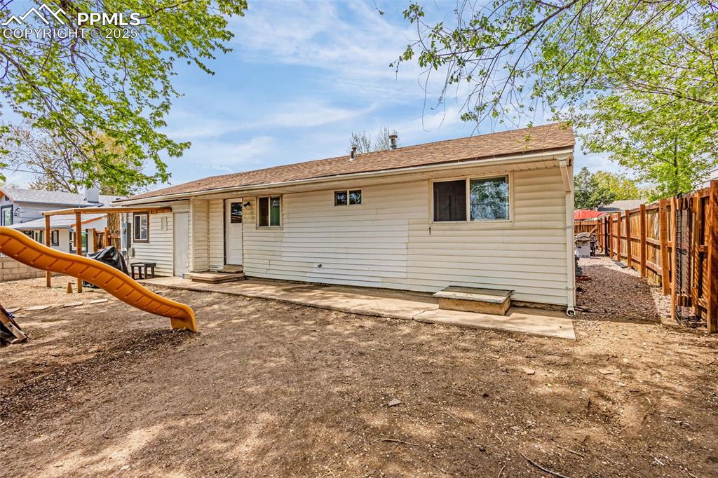 Image 21 of 30: Rear view of property with a playground and a fenced backyard