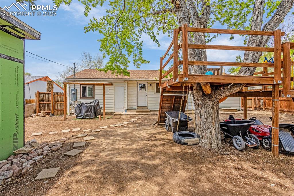 Image 22 of 30: Back of property with fence and roof with shingles