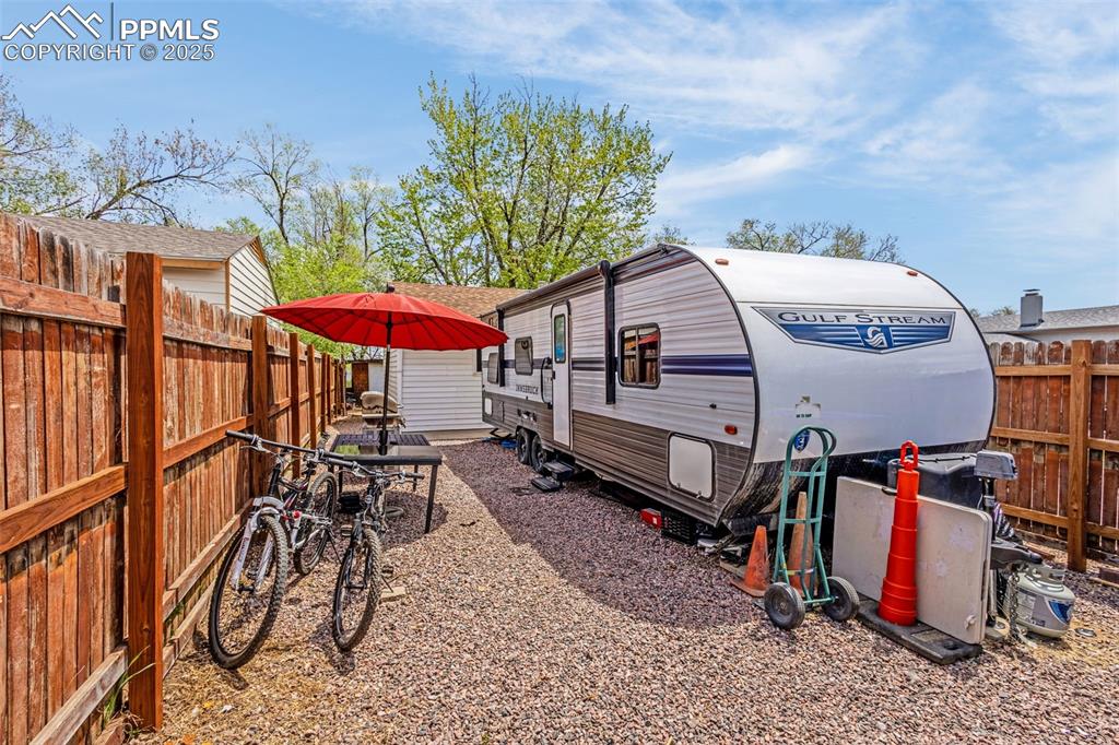 Image 3 of 30: View of side of property featuring a fenced backyard and outdoor dining spa