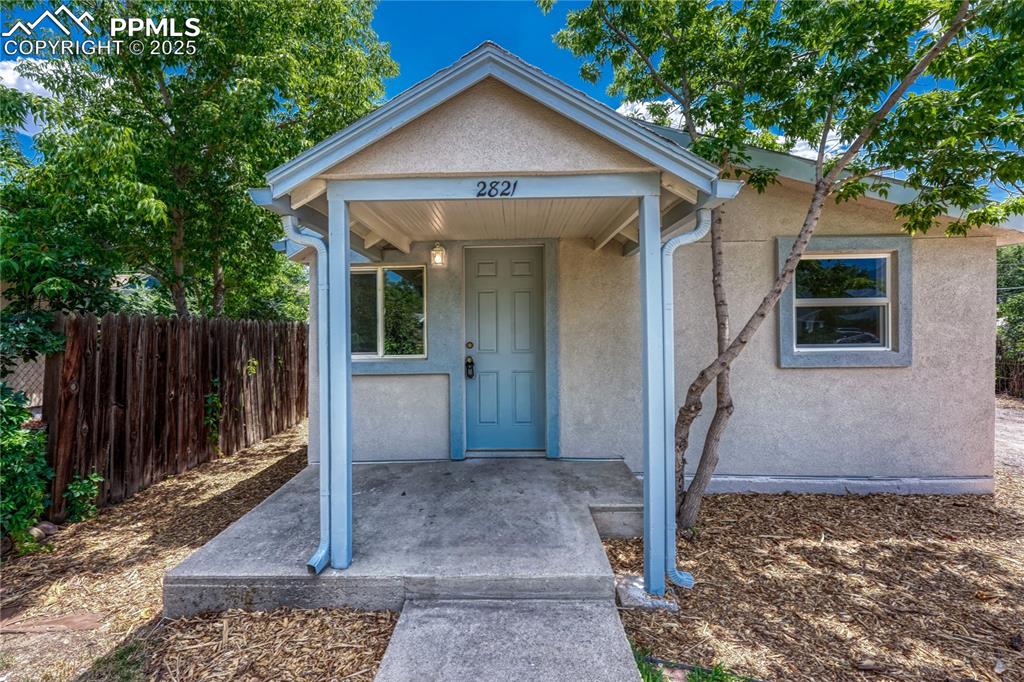 Caption: View of exterior entry with stucco siding
