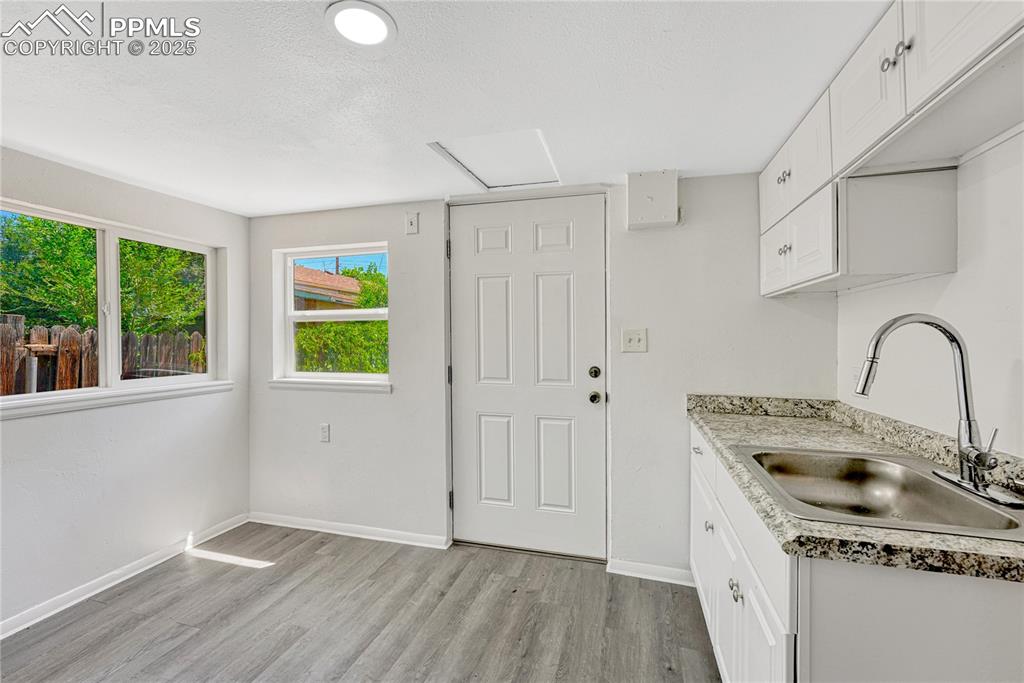 Image 10 of 29: Kitchen featuring light wood-type flooring and white cabinetry