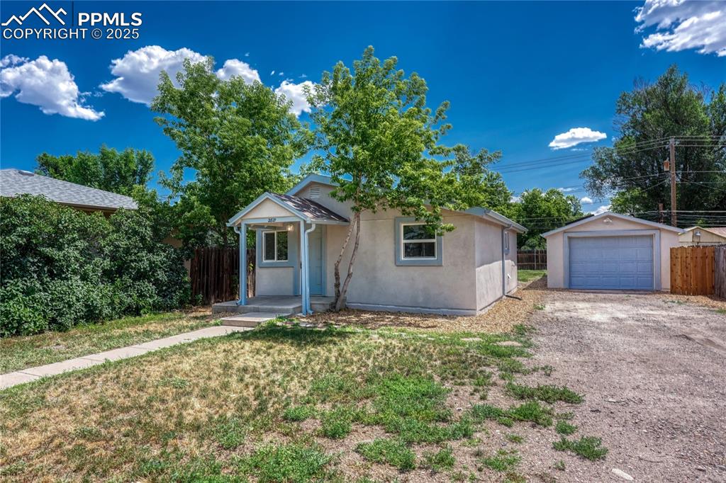 Image 3 of 29: View of front facade featuring gravel driveway, an outbuilding, stucco sidi
